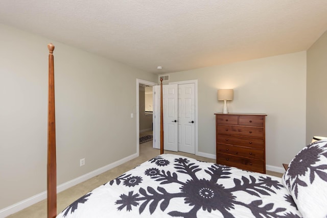 bedroom with visible vents, light colored carpet, a textured ceiling, and baseboards