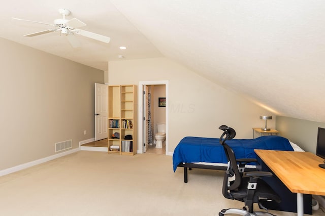 carpeted bedroom featuring lofted ceiling, visible vents, ensuite bathroom, a ceiling fan, and baseboards