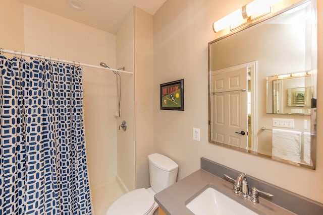 full bathroom featuring tiled shower, vanity, and toilet