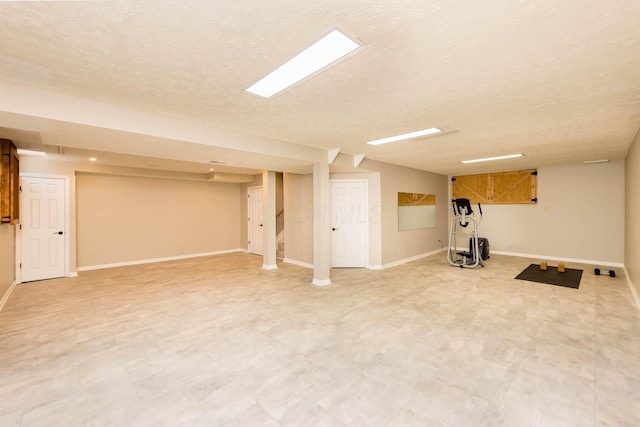 finished below grade area with light floors, stairs, baseboards, and a textured ceiling