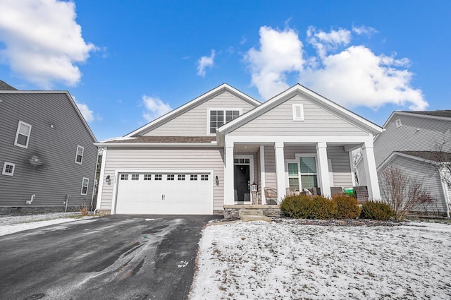 view of front of property with driveway, a garage, and a porch