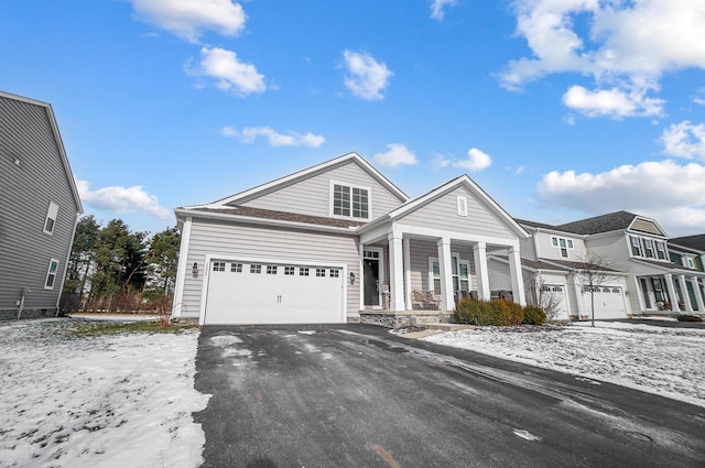 view of front of house with a garage, driveway, and a porch