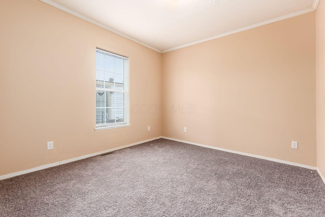 carpeted spare room featuring visible vents, crown molding, and baseboards