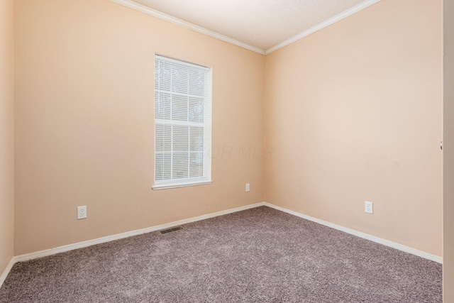 carpeted spare room with ornamental molding, visible vents, and baseboards