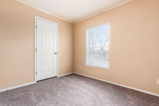 carpeted spare room with baseboards and crown molding