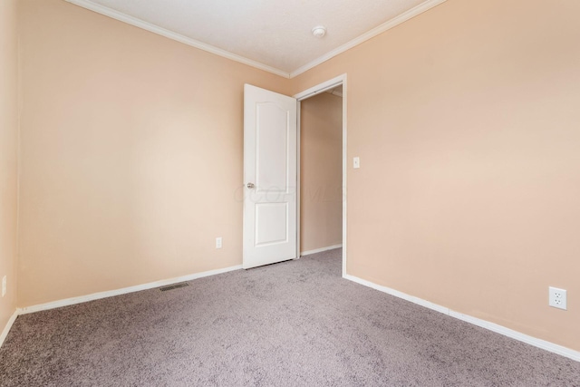 carpeted spare room featuring ornamental molding, visible vents, and baseboards