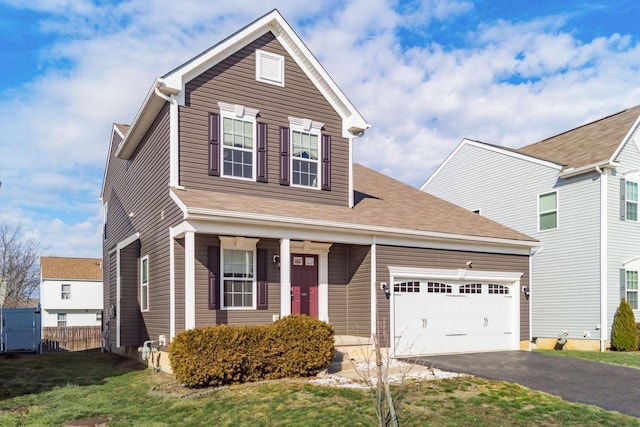 traditional home featuring driveway, an attached garage, fence, and a front yard