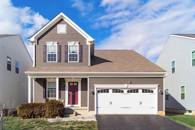 traditional-style home featuring a garage and aphalt driveway