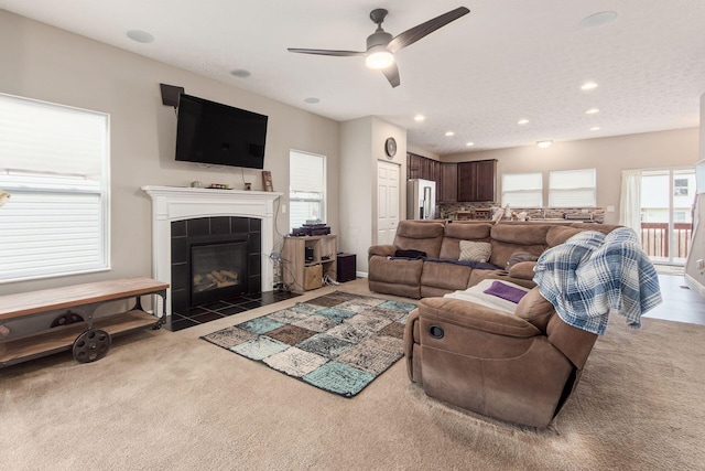 living room featuring carpet, a ceiling fan, a tiled fireplace, and recessed lighting