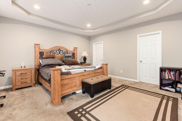 bedroom featuring light carpet, baseboards, a raised ceiling, and recessed lighting