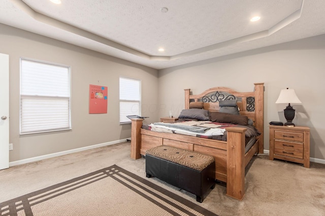 bedroom with light carpet, baseboards, a raised ceiling, a textured ceiling, and recessed lighting