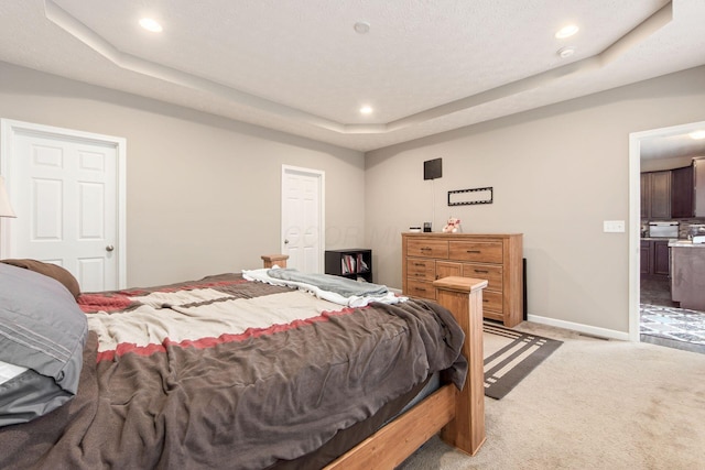 bedroom with baseboards, a tray ceiling, recessed lighting, and light colored carpet