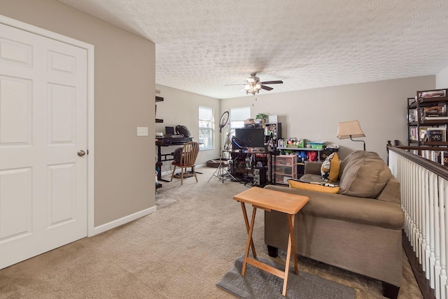 living area featuring carpet flooring, ceiling fan, a textured ceiling, and baseboards