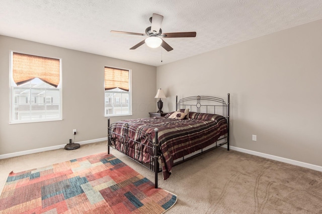 carpeted bedroom featuring a textured ceiling, ceiling fan, and baseboards