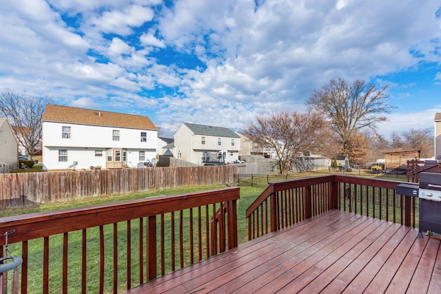 wooden terrace featuring a lawn, a fenced backyard, and a residential view