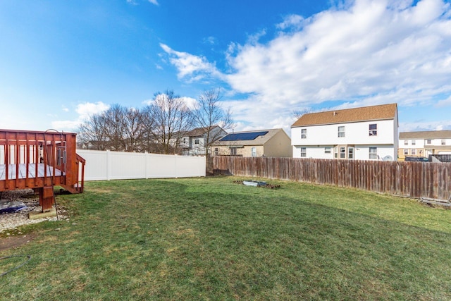 view of yard featuring a fenced backyard, a residential view, and a wooden deck