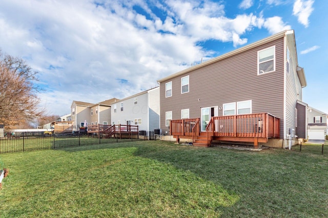 back of house with a residential view, fence, a deck, and a yard