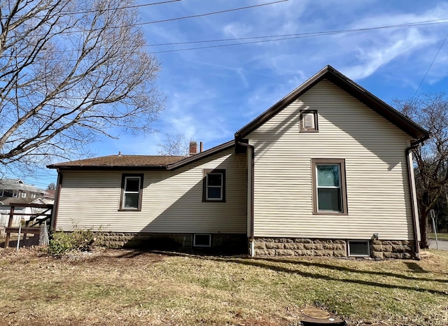 view of side of property featuring a lawn and a chimney