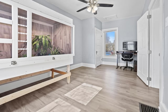 office space with attic access, visible vents, baseboards, and wood finished floors