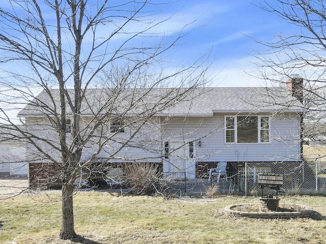 exterior space with a chimney, a lawn, and roof with shingles