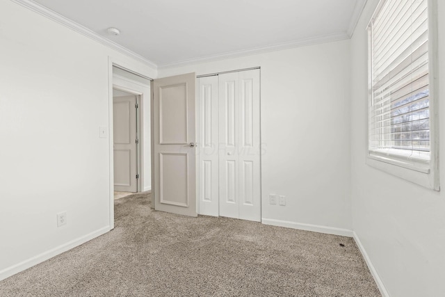 unfurnished bedroom featuring ornamental molding, a closet, carpet flooring, and baseboards