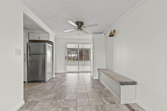 kitchen featuring ornamental molding, freestanding refrigerator, baseboards, and a ceiling fan