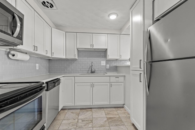 kitchen featuring stainless steel appliances, a sink, visible vents, white cabinetry, and light countertops