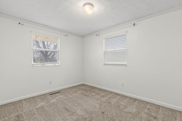 unfurnished room featuring a textured ceiling, carpet floors, ornamental molding, and baseboards