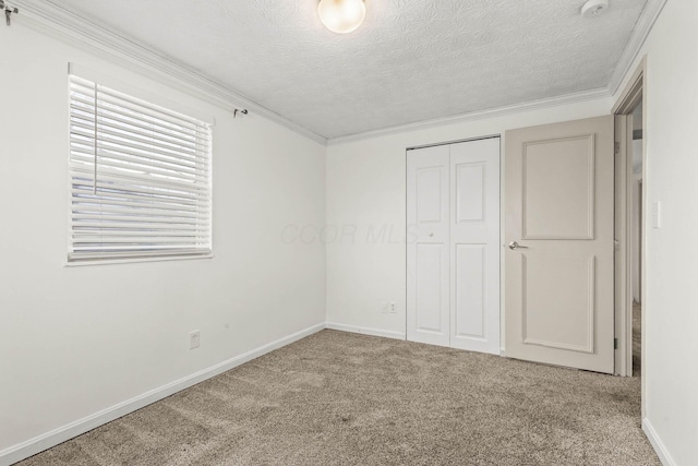 unfurnished bedroom with carpet floors, a closet, crown molding, and a textured ceiling