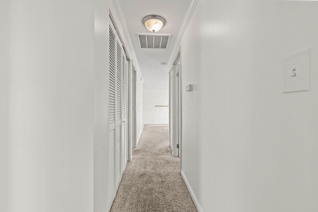 hallway featuring carpet, visible vents, and baseboards