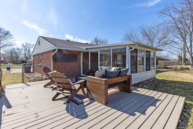 wooden deck featuring a sunroom, outdoor lounge area, fence, and a lawn