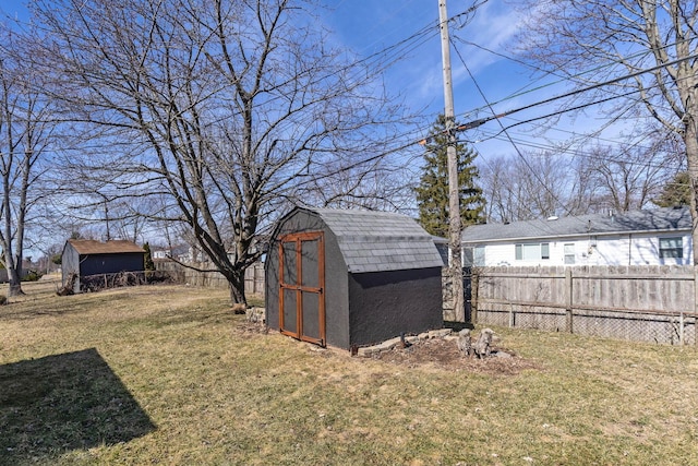 view of yard with fence private yard, a storage shed, and an outbuilding