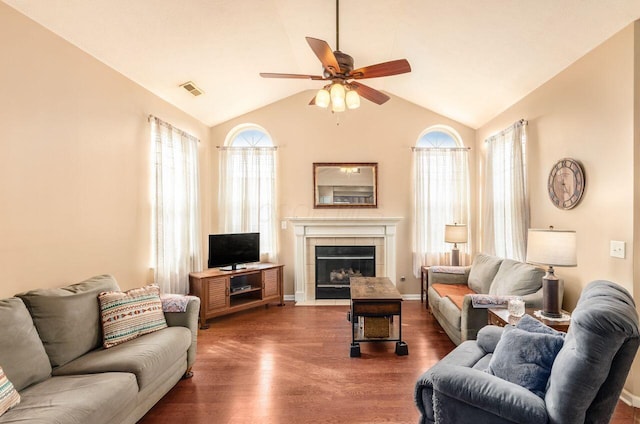 living room featuring plenty of natural light, a fireplace, vaulted ceiling, and wood finished floors