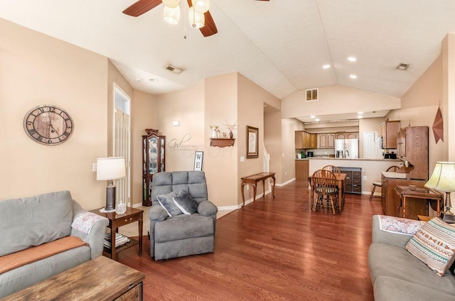 living room featuring lofted ceiling, baseboards, visible vents, and wood finished floors