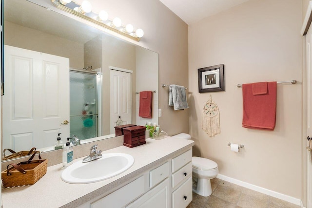 bathroom featuring baseboards, toilet, tile patterned floors, vanity, and a shower stall