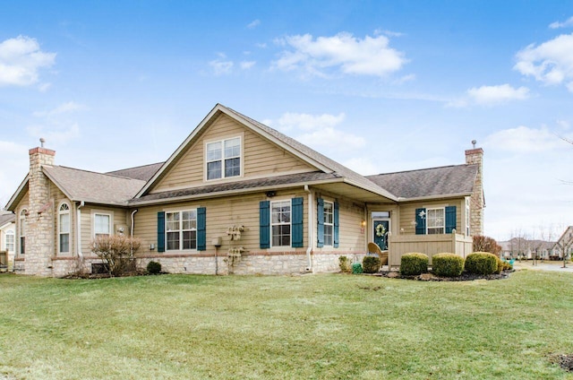 view of front of home with a front lawn, a chimney, and a shingled roof