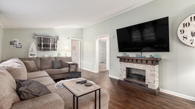 living area with crown molding, dark wood finished floors, lofted ceiling, a stone fireplace, and baseboards