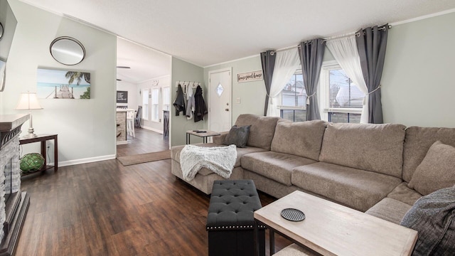 living area featuring lofted ceiling, crown molding, wood finished floors, and a healthy amount of sunlight