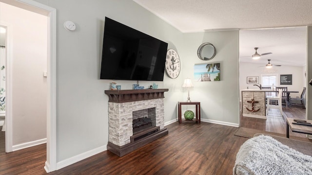 living area with lofted ceiling, a fireplace, wood finished floors, and baseboards