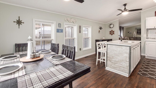 dining space featuring ceiling fan, dark wood-type flooring, ornamental molding, and baseboards