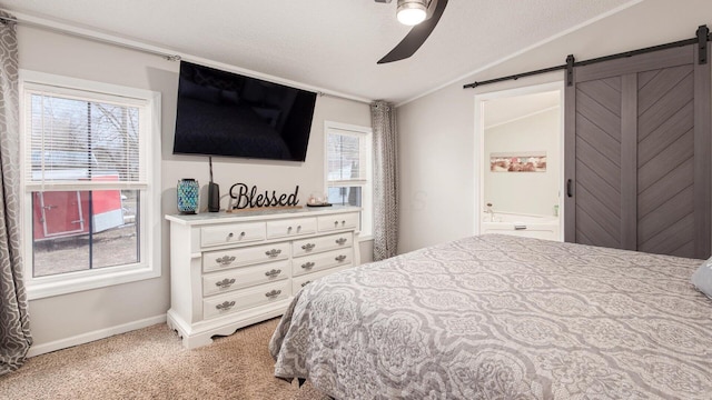 carpeted bedroom with a barn door, a ceiling fan, lofted ceiling, ensuite bathroom, and a textured ceiling