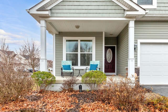 doorway to property with a garage and covered porch