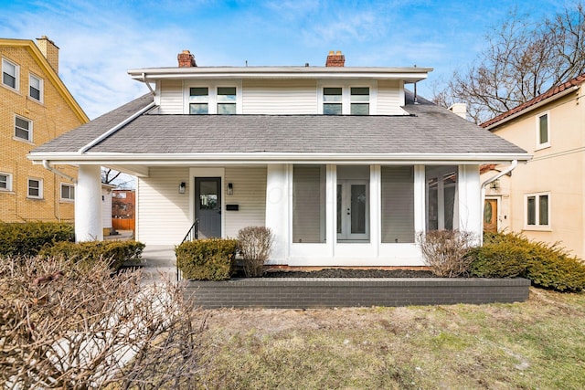 view of front of home featuring a shingled roof and a chimney