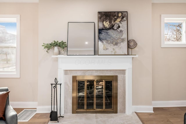 details featuring a fireplace, wood finished floors, and baseboards