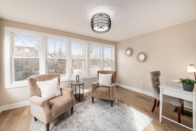 sitting room featuring baseboards and light wood-style floors