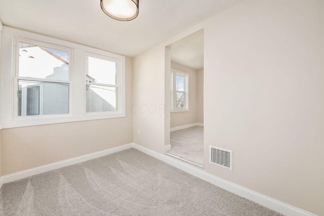 empty room featuring baseboards, visible vents, and carpet flooring