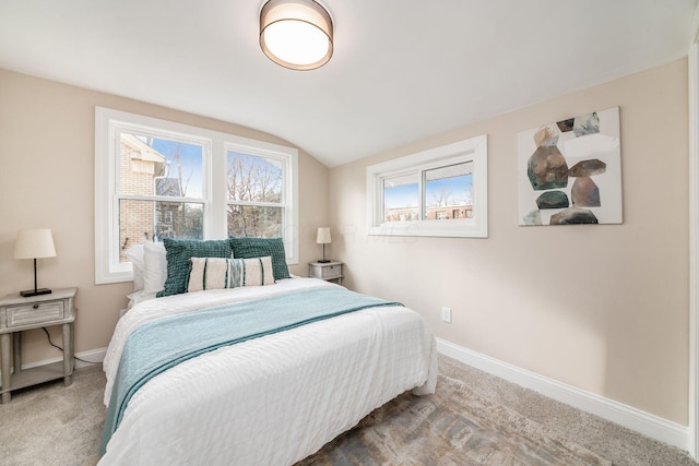 carpeted bedroom with vaulted ceiling and baseboards