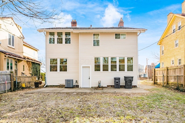 back of house with fence private yard, a patio area, a chimney, and central AC unit