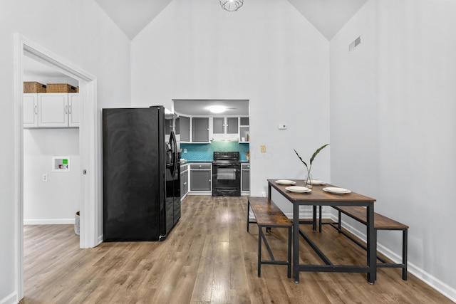 143 Walnut St, Sunbury, OH 43074 - kitchen featuring black appliances, high vaulted ceiling, light wood-type flooring, and baseboards