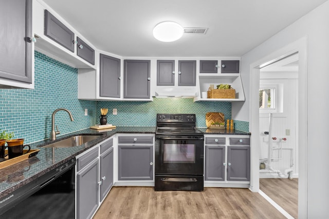 143 Walnut St, Sunbury, OH 43074 - kitchen featuring black appliances, a sink, light wood-style floors, gray cabinetry, and dark stone counters